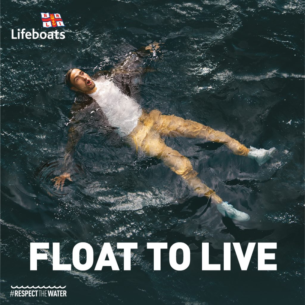 Royal National Lifeboat Institution image showing a man floating in a large body of water