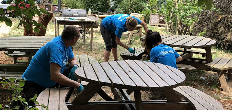Waterforce volunteers painting an outside table