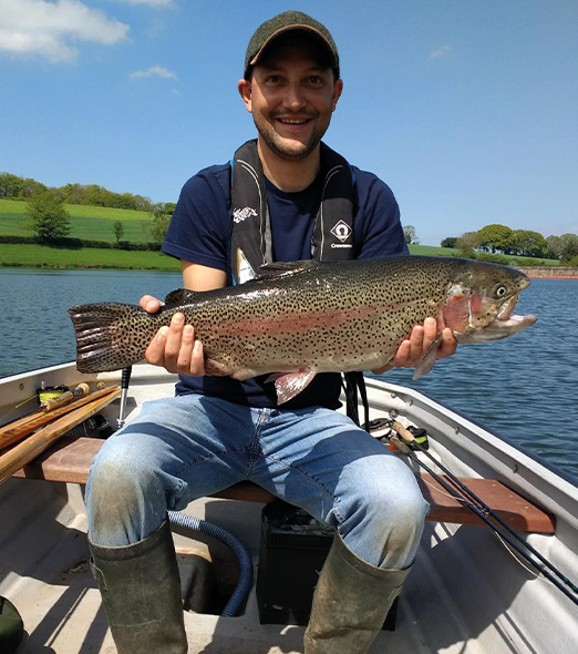 Angler In a Boat Fishing holding a fish